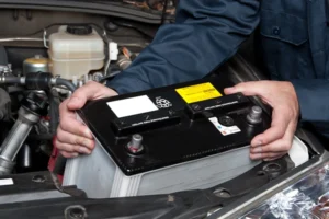 Technician replacing car battery